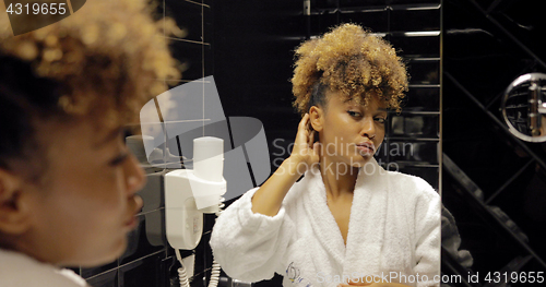 Image of Confident woman grooming in glass