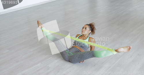 Image of Woman stretching legs with band