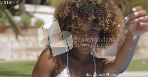 Image of Young charming girl playing with water