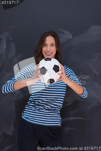 Image of woman holding a soccer ball in front of chalk drawing board