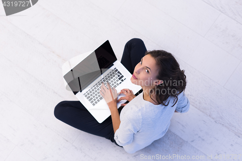 Image of women using laptop computer on the floor top view
