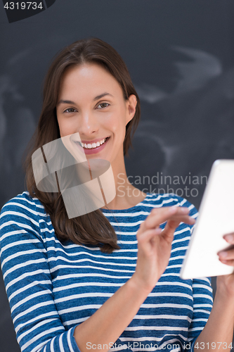 Image of woman using tablet  in front of chalk drawing board