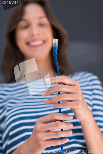 Image of woman holding a internet cable in front of chalk drawing board