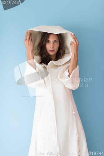 Image of woman in a white coat with hood isolated on blue background