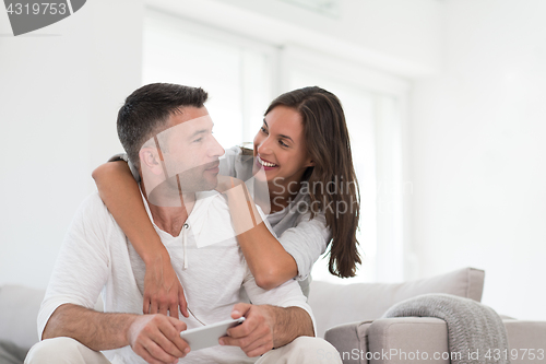 Image of happy couple using mobile phone at home