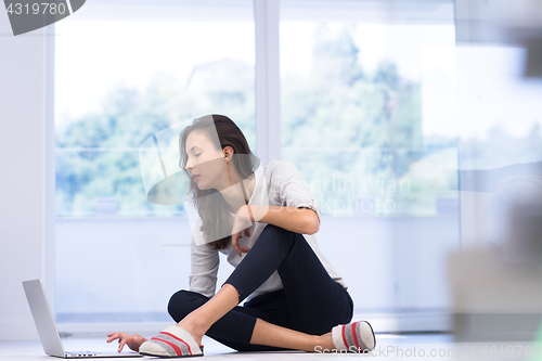 Image of young women using laptop computer on the floor