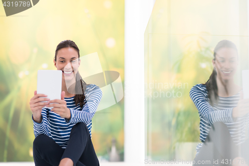 Image of young women using tablet computer on the floor