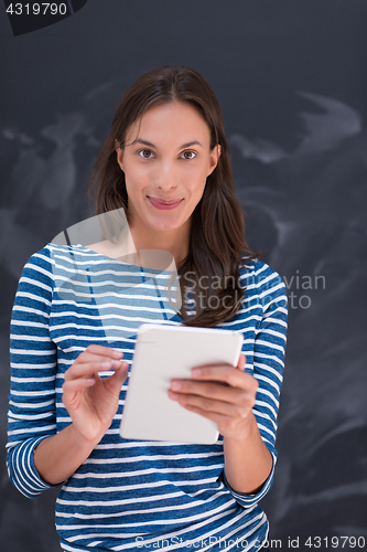 Image of woman using tablet  in front of chalk drawing board