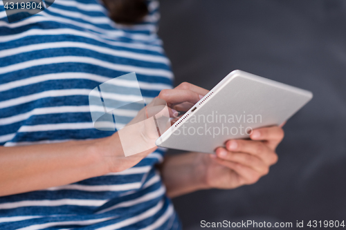 Image of woman using tablet  in front of chalk drawing board