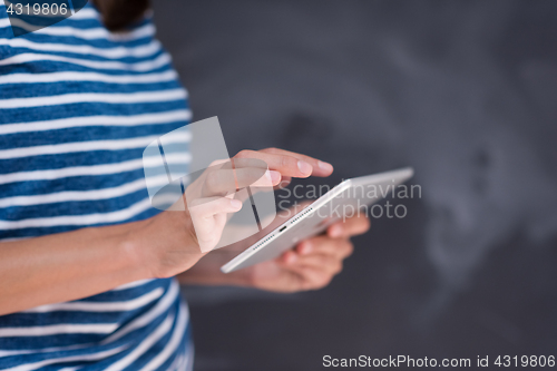 Image of woman using tablet  in front of chalk drawing board