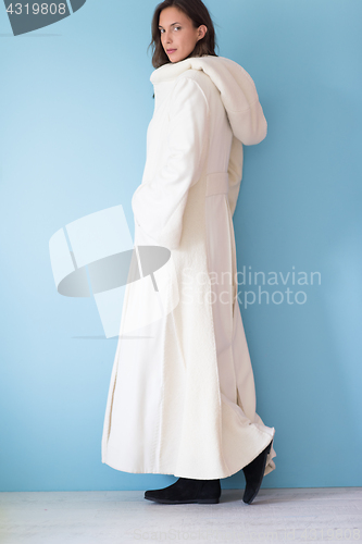 Image of woman in a white coat with hood isolated on blue background