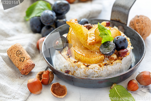 Image of Grilled camembert with pears and black grapes.