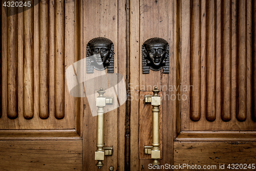 Image of Sphinx heads entrance on wooden door