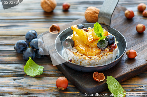 Image of Baked camembert with pears, black grapes and hazelnuts.