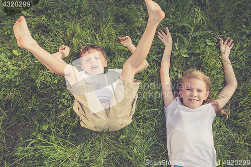 Image of Two happy children playing on the grass at the day time. 