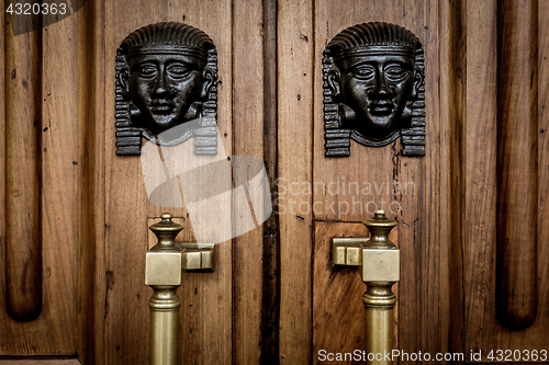 Image of Sphinx heads entrance on wooden door