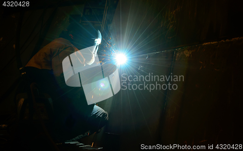 Image of Woman worker welding  