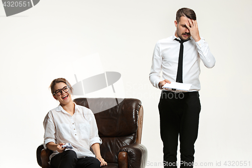 Image of The young man and beautiful woman in business suit at office on white background