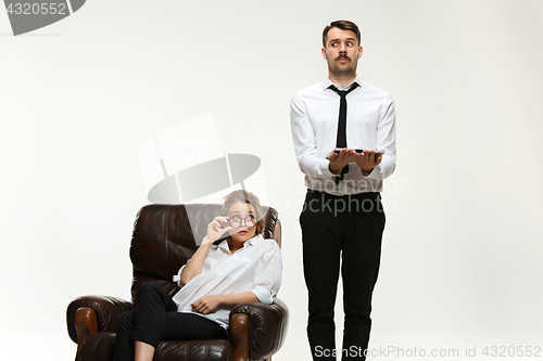 Image of The young man and beautiful woman in business suit at office on white background