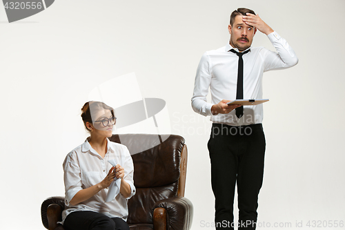 Image of The young man and beautiful woman in business suit at office on white background