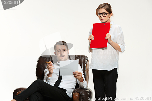 Image of The young man and beautiful woman in business suit at office on white background