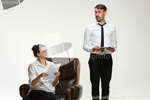 Image of The young man and beautiful woman in business suit at office on white background