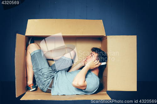 Image of Introvert concept. The man sitting inside box and working with laptop