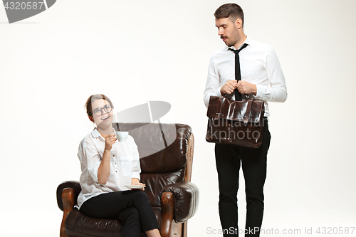 Image of The young man and beautiful woman in business suit at office on white background