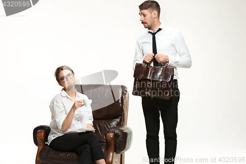 Image of The young man and beautiful woman in business suit at office on white background