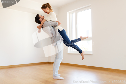 Image of happy couple at empty room of new home