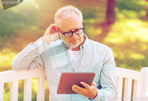 Image of senior man with tablet pc at summer park