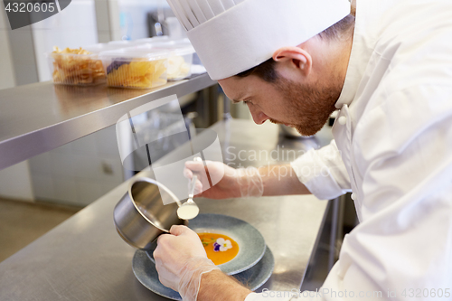 Image of happy male chef cooking food at restaurant kitchen