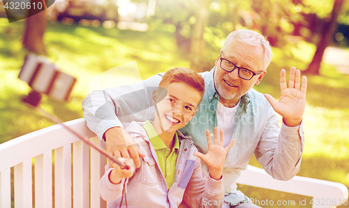 Image of old man and boy taking selfie by smartphone