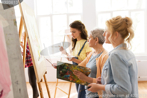 Image of women with easel and palettes at art school