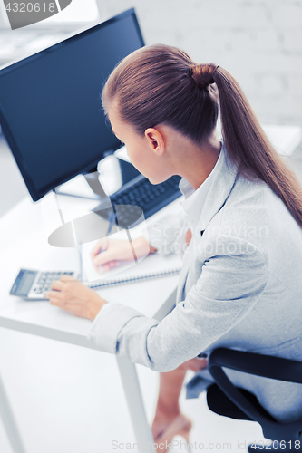 Image of businesswoman with notebook and calculator