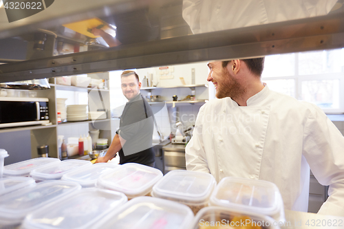 Image of chef and cook cooking food at restaurant kitchen