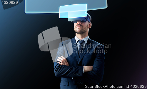 Image of businessman in virtual reality headset over black