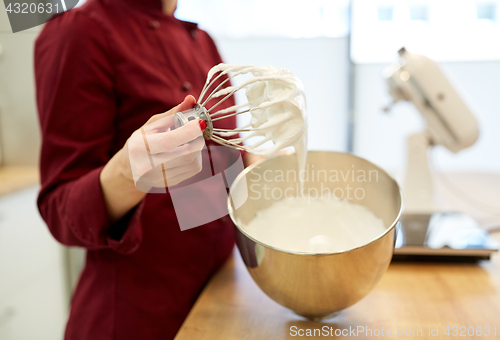 Image of chef with whisk and whipped egg whites at kitchen