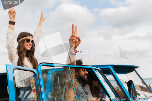 Image of hippie friends at minivan car showing peace sign