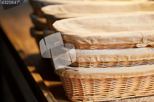 Image of bakery wicker baskets on wooden kitchen table