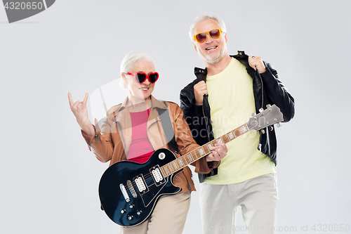 Image of senior couple with guitar showing rock hand sign