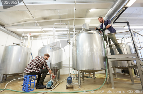 Image of men working at craft beer brewery kettles