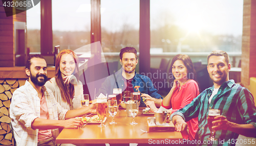 Image of friends dining and drinking beer at restaurant