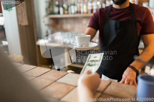 Image of man or bartender serving customer at coffee shop