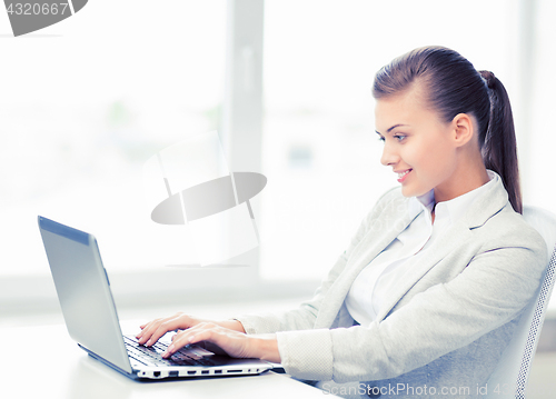 Image of businesswoman with laptop in office