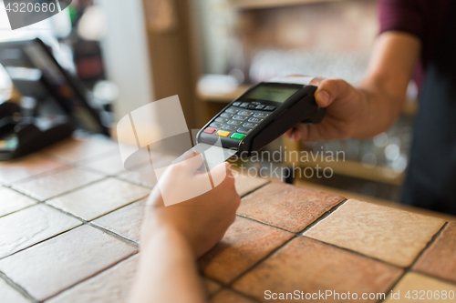 Image of hands with payment terminal and credit card