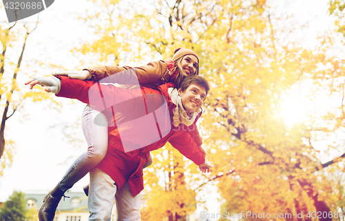 Image of happy young couple having fun in autumn park