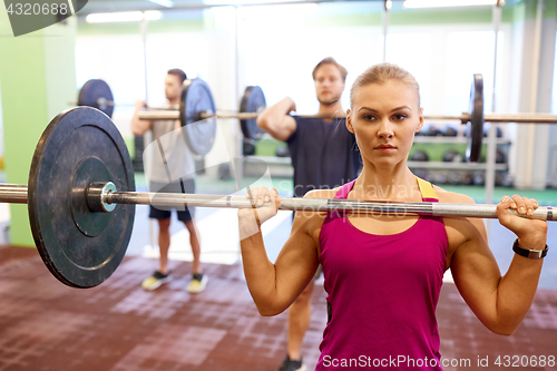 Image of group of people training with barbells in gym