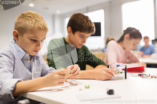 Image of happy children building robots at robotics school