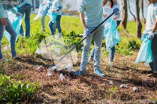 Image of volunteers with garbage bags cleaning park area